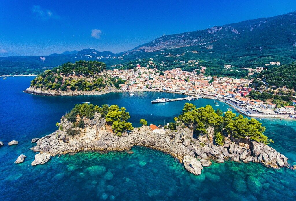 Vue aérienne de Parga, une charmante ville côtière entourée de collines verdoyantes et d’eaux turquoise.