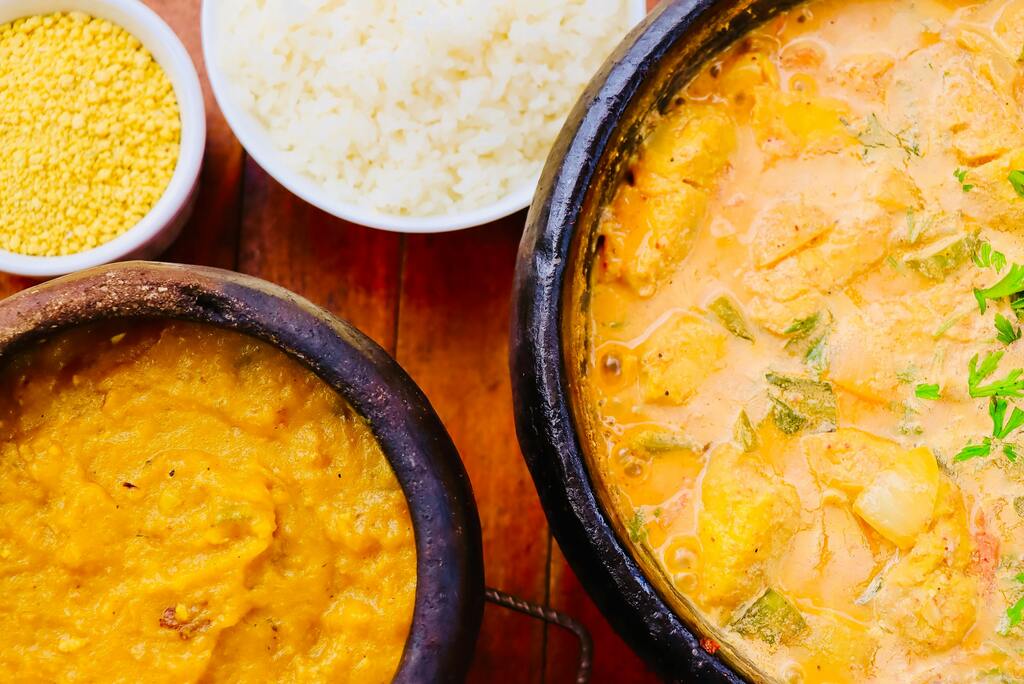 Moqueca de pescado con leche de coco y acompañamientos típicos brasileños como arroz y farofa