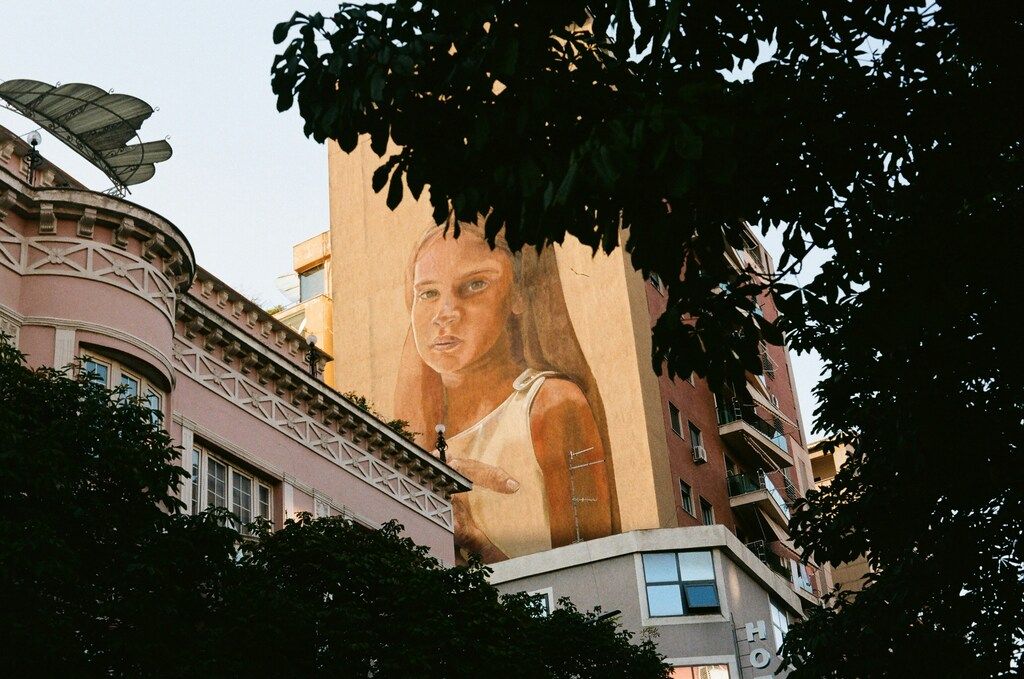 Mural de una mujer joven pintado en un edificio de Tirana