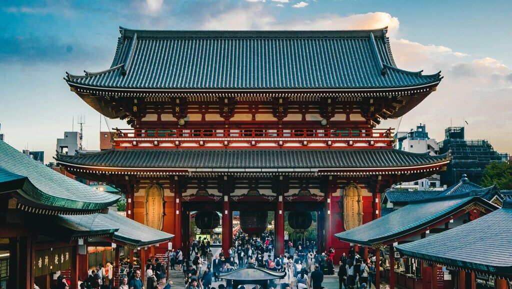 Vista frontal del famoso templo Sensō-ji con turistas y visitantes al atardecer.