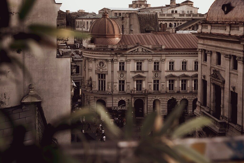 Vista aérea de un elegante edificio de estilo neoclásico con cúpula roja en el centro histórico de Bucarest.