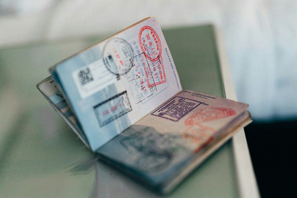 Primer plano de un pasaporte abierto con sellos de entrada y salida de varios países.