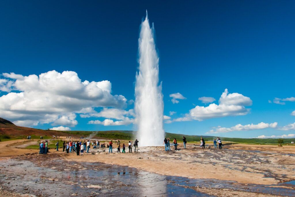 El famoso géiser Strokkur en Islandia erupcionando bajo un cielo azul brillante