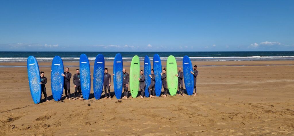 Grupo de surfistas de Weroad con tablas en la playa de Essaouira.