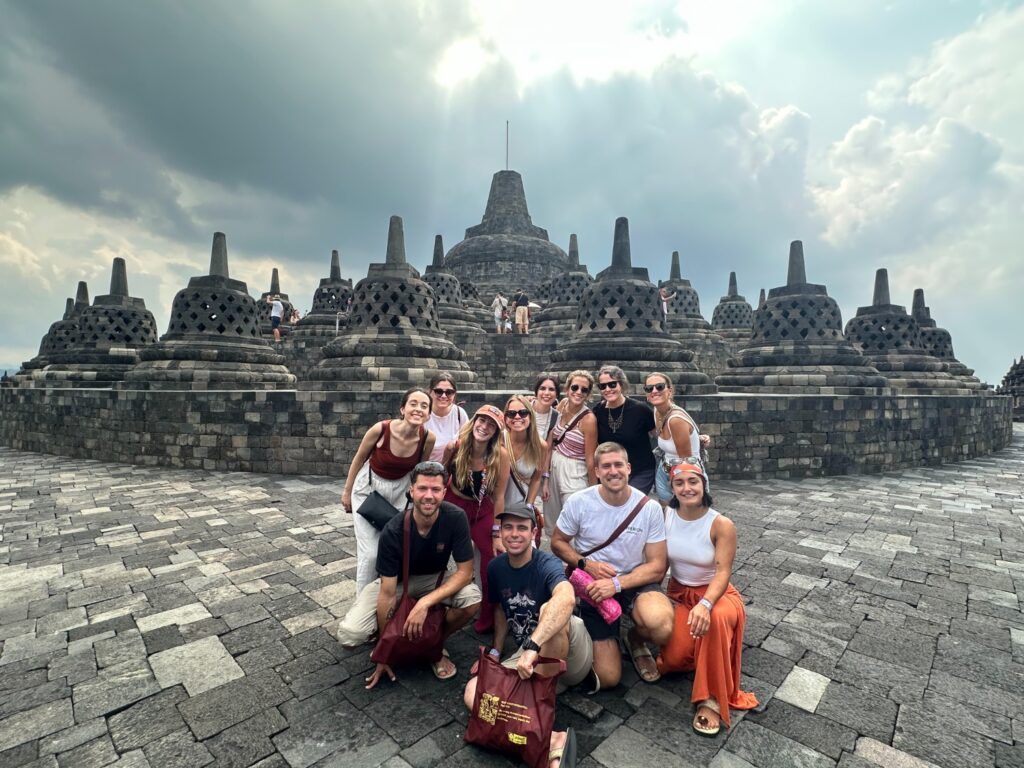 Grupo de viajeros WeRoad posando en la cima del Templo Budista de Borobudur, Java.