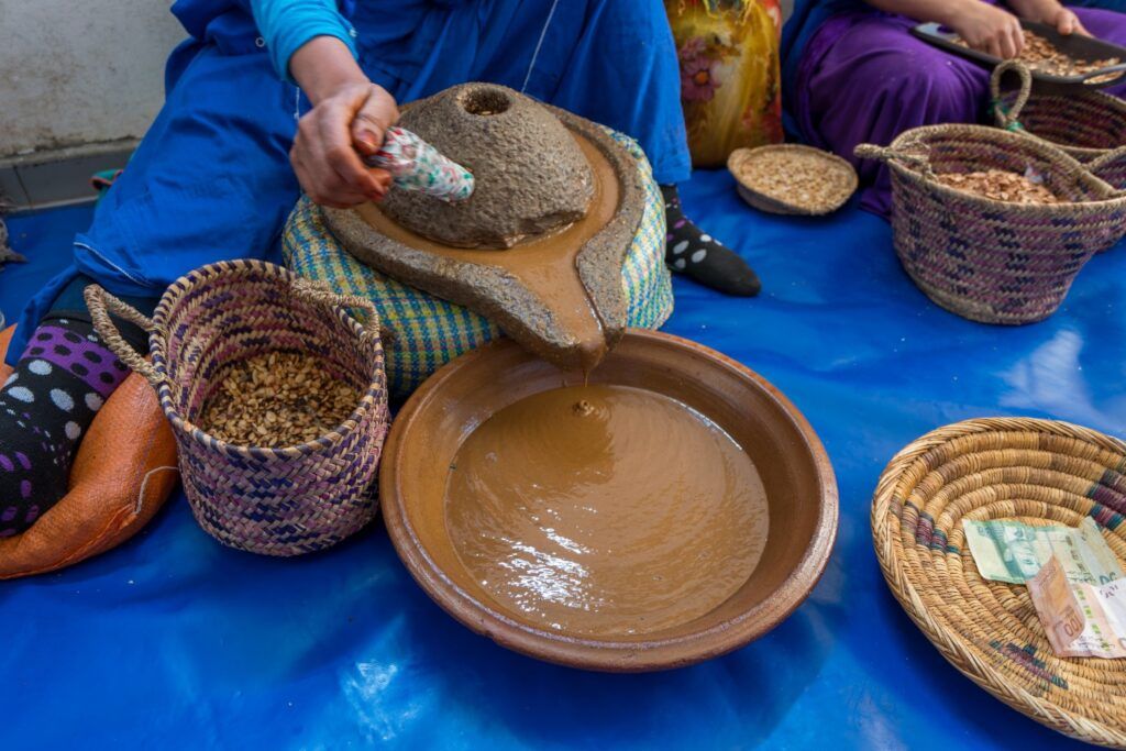 Mujer marroquí moliendo las semillas para la producción artesanal de aceite de argán.