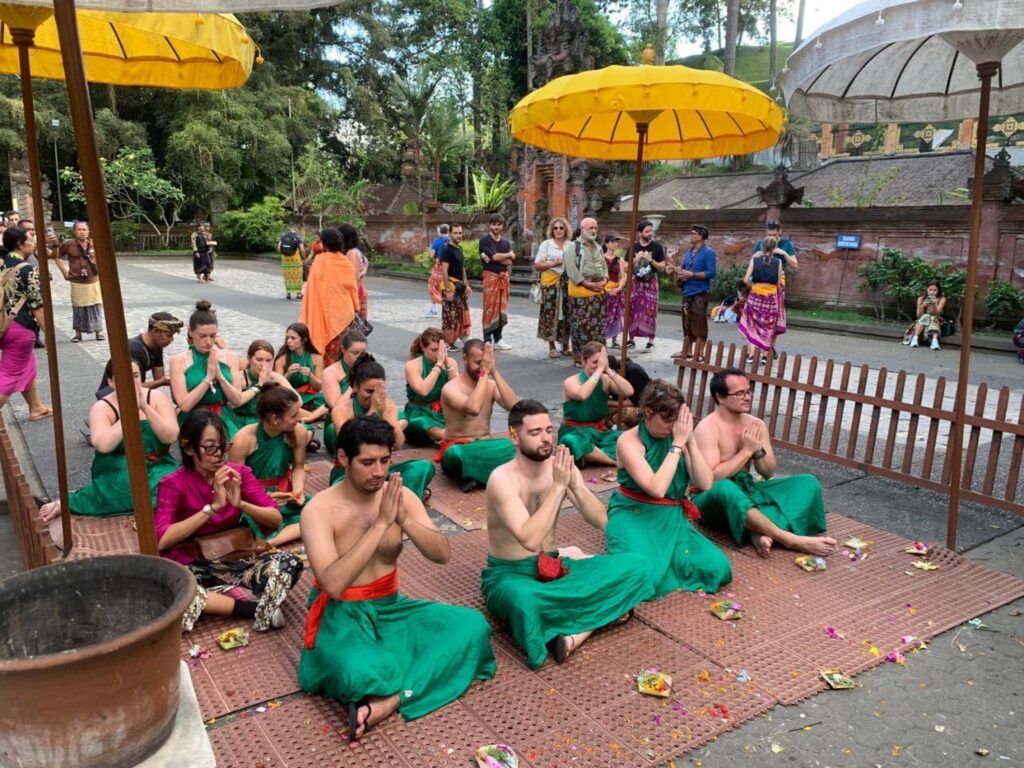 Grupo realizando una ceremonia en el Templo Tirta Empul, Bali, vestidos con sarong.