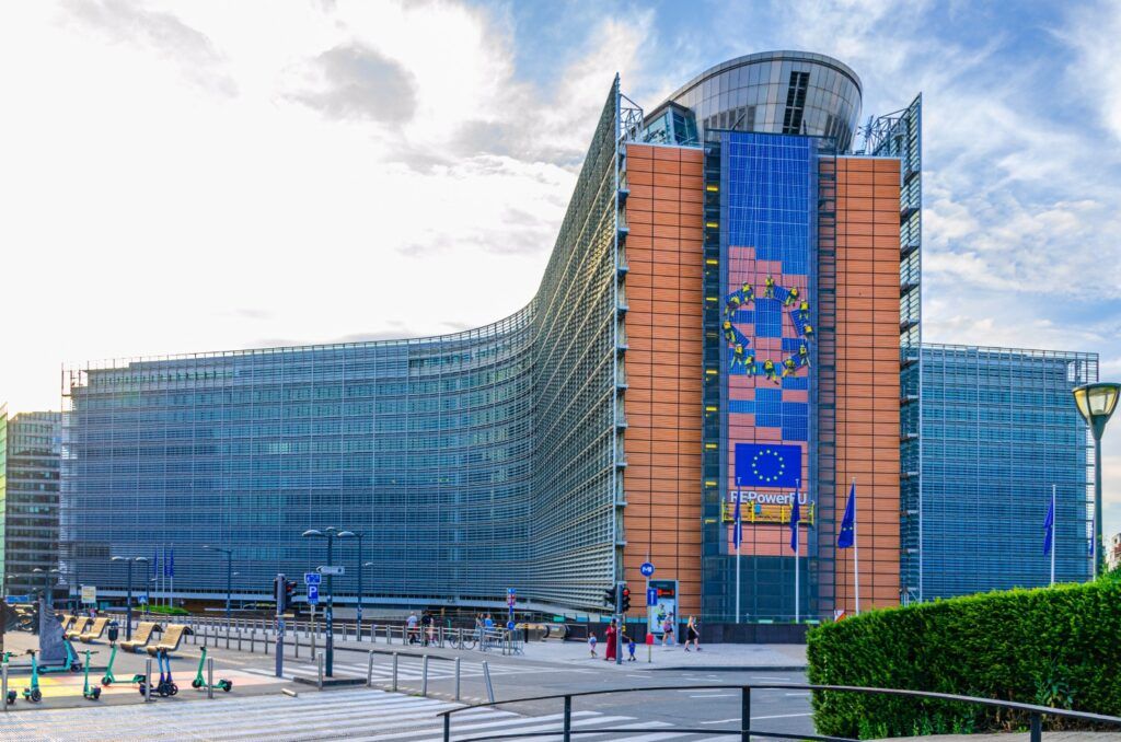 El edificio Berlaymont, sede de la Comisión Europea en Bruselas, con su fachada curva y la bandera de la UE.