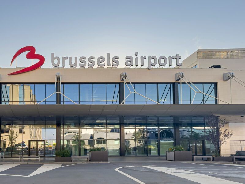 Vista exterior de la entrada principal del Aeropuerto de Bruselas (Brussels Airport), con el logo rojo en forma de corazón y el edificio moderno.