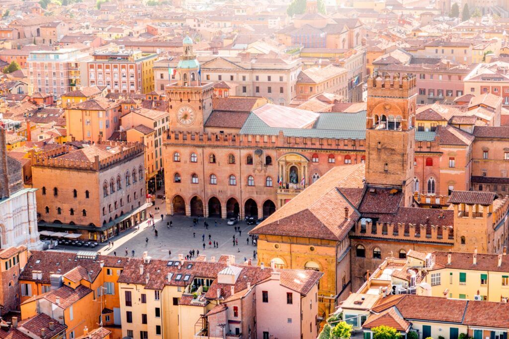 Vista aérea de la Piazza Maggiore en Bolonia, destacando el Palazzo d'Accursio y la arquitectura medieval.