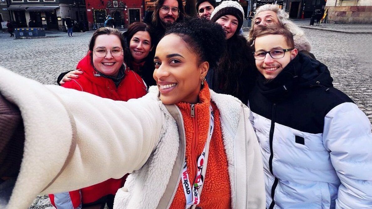 Un grupo de viajeros de WeRoad sonriendo durante un selfie grupal en una plaza de Austria durante el invierno.